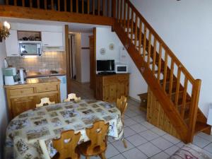 ベッサンにあるRésidence Les Balcons Des Curtious - Studio mezzanine - 4 personnes MAE-2113のテーブルと階段のあるキッチンとダイニングルーム