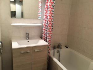 a bathroom with a sink and a bath tub at Résidence Colombaz - Studio pour 4 Personnes MAE-2153 in Lanslevillard