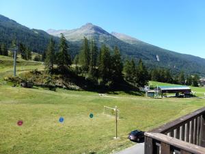 a view of a field with a gazebo and mountains at Résidence Colombaz - Studio pour 4 Personnes MAE-2153 in Lanslevillard