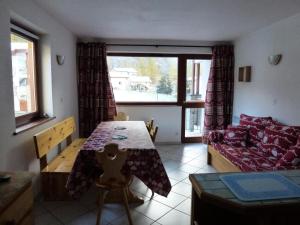 un salon avec une table et un canapé dans l'établissement Résidence Les Balcons Des Curtious - Appartement 2 pièces - 6 personnes MAE-2173, à Bessans