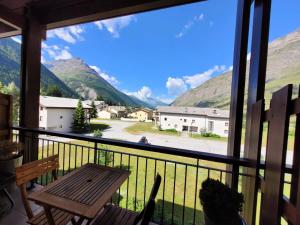 a balcony with a table and a view of mountains at Résidence Les Balcons Des Curtious - Appartement 3 pièces - 6 personnes MAE-2183 in Bessans