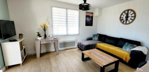 a living room with a couch and a table at Maison La Guitoune Fautaise in L'Aiguillon-la-Presqu'île