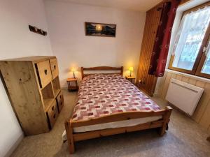 Un dormitorio con una cama y dos ventanas. en Résidence Lanslevillard Quartier Eglise - 3 Pièces pour 6 Personnes MAE-2203, en Lanslevillard
