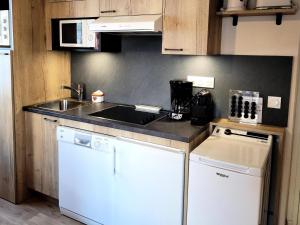 una pequeña cocina con fregadero y lavavajillas en Résidence Lanslevillard Quartier Eglise - 3 Pièces pour 6 Personnes MAE-2203, en Lanslevillard 1 foto más