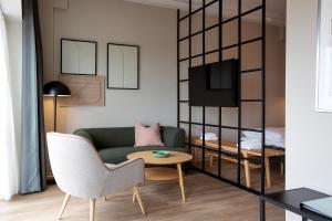 a living room with a couch and a table at Cabinn Plus Esbjerg in Esbjerg