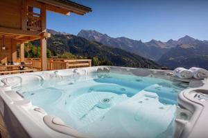a hot tub with a view of a mountain at Chalet Lambersens Serbijanka in Manigod