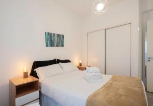 a bedroom with a large white bed with two lamps at Moderno piso 10! Garage! River - ViaVivaChino in Buenos Aires