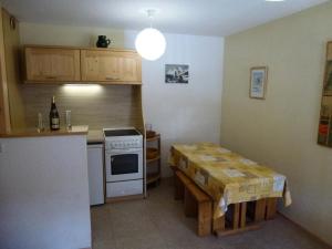 a small kitchen with a table and a stove and a counter at Résidence Belle - 2 Pièces pour 4 Personnes MAE-2353 in Lanslevillard