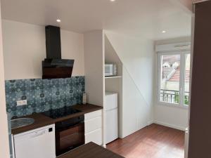 a kitchen with white cabinets and a window at Disneyland Paris-Meaux 20 minutes in Meaux
