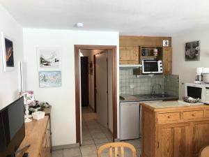 a kitchen with a sink and a stove at Résidence Les Balcons Des Curtious - Studio pour 4 Personnes MAE-2363 in Bessans +1 photo