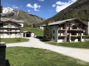 a apartment building with mountains in the background at Résidence Les Balcons Des Curtious - Studio pour 4 Personnes MAE-2363 in Bessans