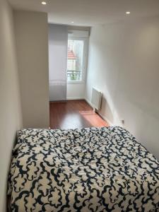 a bedroom with a bed with a black and white comforter at Disneyland Paris-Meaux 20 minutes in Meaux