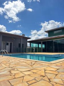 a swimming pool in front of a house at Pousada Duarte in Capitólio