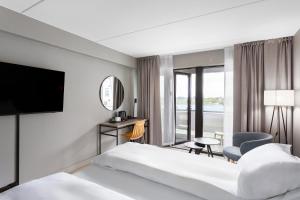 a hotel room with a bed and a tv at Radisson Hotel Haugesund in Haugesund +100 photos
