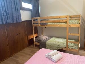 a bedroom with two bunk beds and a pink rug at Mansarda Cadore in Pieve di Cadore