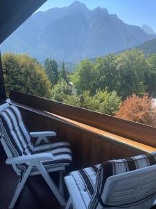 two chairs on a balcony with a view of mountains at Mansarda Cadore in Pieve di Cadore