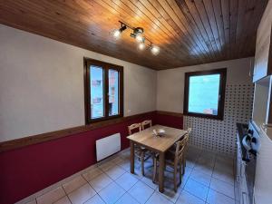 a dining room with a table and some windows at Résidence Andagne - Appartement spacieux bien situé MAE-2423 in Bessans +1 photo