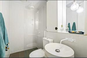 a white bathroom with a toilet and a sink at City Vibe on Dorcas Southbank in Melbourne