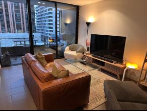 a living room with a couch and a flat screen tv at City Vibe on Dorcas Southbank in Melbourne