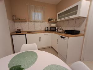 una pequeña cocina con armarios blancos y microondas en Studio apartman Karli, en Rijeka
