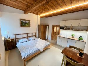 a bedroom with a bed and a table and a kitchen at Apartmány Bouda 230 in Pec pod Sněžkou