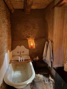 a bathroom with a bath tub in a cave at Klipkraal Cottage in Calitzdorp +34 photos