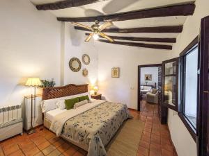 Un dormitorio con una cama y un ventilador de techo. en Rural House in Antequera, en La Joya