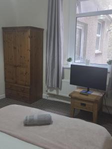 a bedroom with a bed and a computer monitor on a table at 52 - room 2 - smart TV in Swansea