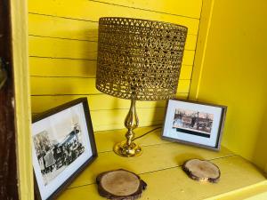 a table with a lamp and pictures on it at The showman wagon in Berwick Saint John +24 photos