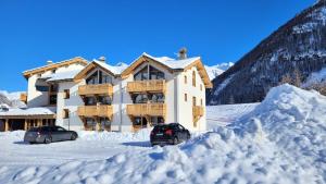 a house in the snow with two cars parked at Résidence Cokott - 2 Pièces pour 4 Personnes MAE-2603 in Bessans