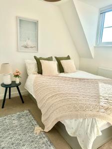 a bedroom with a large bed with white sheets and a window at New Five bed house with parking in St leonards in St. Leonards
