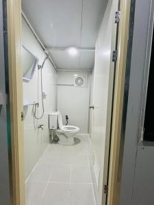 a small bathroom with a toilet and a shower at Datok homestay in Ban Khok Tarot