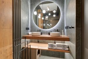 ein Badezimmer mit zwei Waschbecken und einem Spiegel in der Unterkunft Porto Letnica Apartments with Gym & Parking by Lion Apartments in Danzig