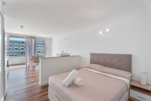 Un dormitorio blanco con una cama y un balcón. en Studio Golf del Sur, en San Miguel de Abona 21 fotos más