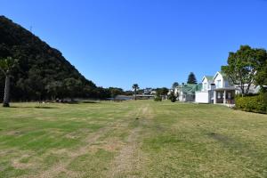 a large grass field in front of houses at Sea and Soul, River Club Villa in Plettenberg Bay