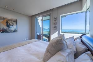 Un dormitorio con una cama y una ventana grande. en Dolphin View Cabana Beach House, en Cape Town 52 fotos más