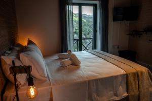a bedroom with a bed with two towels on it at Pine View Boutique Hotel Adults Only in Saittas