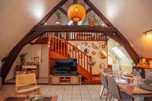 a living room with a dining table and a staircase at Bali Surya in Chalon-sur-Saône