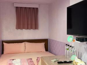 a room with a bed with a television and a table at Jiufen Ligin B&B in Jiufen +15 photos
