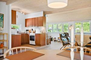 a kitchen with wooden cabinets and a table and chairs at 30383-Odder-Lyngbakkevej-10 in Odder +19 photos