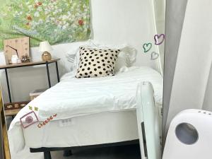 a small white bed in a small room at 강동둔촌 bnb in Seoul