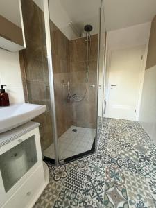 a bathroom with a shower with a glass door at Wohnen am Main in Würzburg +5 photos