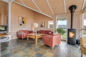 una sala de estar con un sofá y una chimenea en 40541-Juelsminde-Pot-Strandby-417, en Sønderby