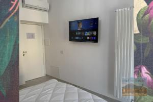 a room with a flat screen tv on a wall at B&B Sweet Ruins in Ercolano +10 photos