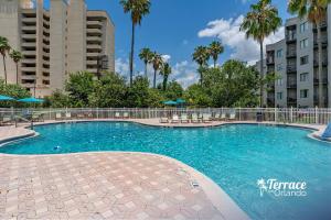 a large swimming pool with palm trees and buildings at Lake View Top Floor 2 Bed 2 Bath Condo with Balcony in Orlando