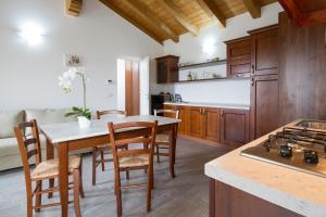 a kitchen with wooden cabinets and a table and chairs at Casa Martina in Polizza