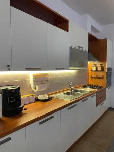 a white kitchen with a sink and a microwave at Roero House in Asti