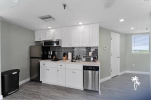 a kitchen with white cabinets and a refrigerator at Lake View Top Floor 2 Bed 2 Bath Condo with Balcony in Orlando