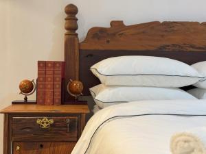 a bedroom with a bed with white pillows and a table at FlexiStay Hotel in Cape Town