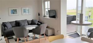 a living room with a couch and a table and chairs at 40128-Juelsminde-Strandengen-41 in Juelsminde